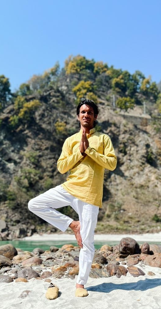Devesh practising yoga beside the river